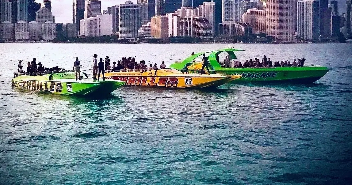 Thriller speedboats with passengers in front of the downtown Miami skyline