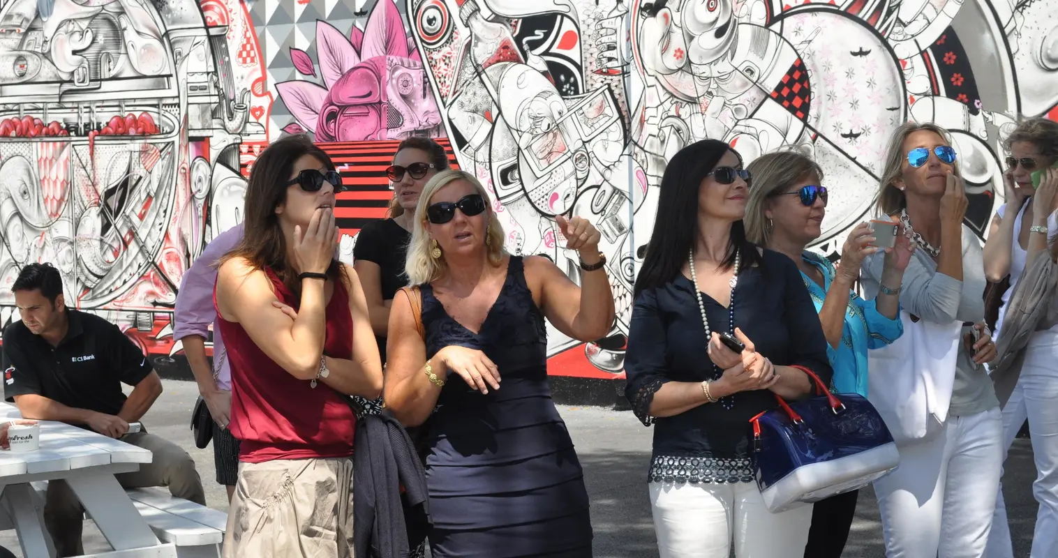 Guests looking up at a black-and-white Wynwood mural