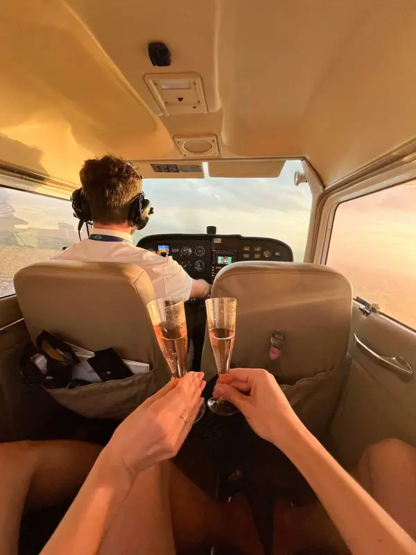 Passengers toasting with glasses behind the pilot in a Cessna cabin