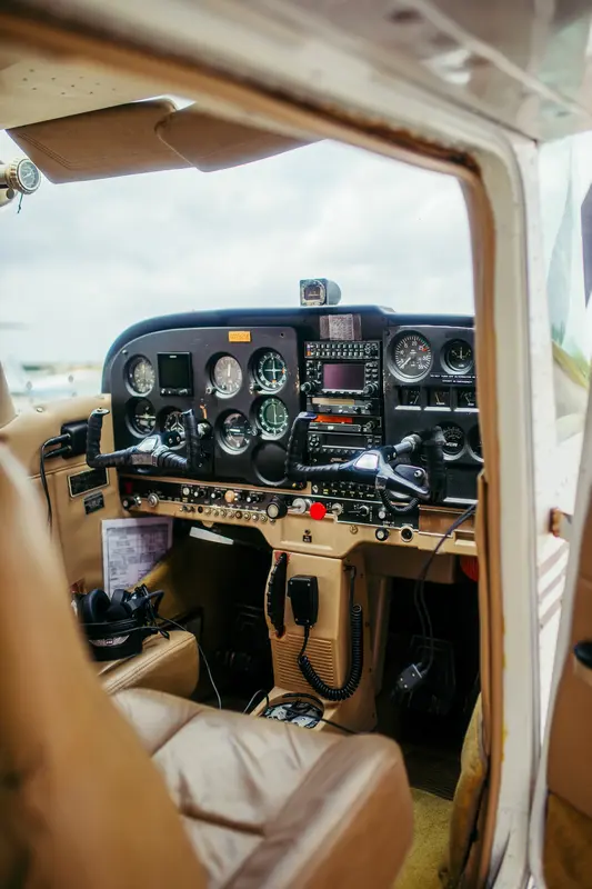 The cockpit instrument panel seen through an open Cessna door