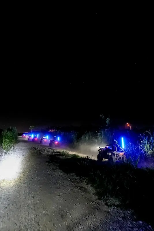 ATVs with headlights on a dark trail