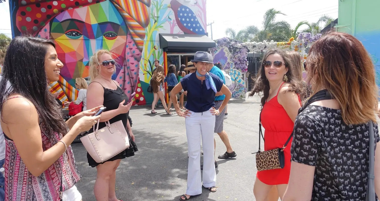 Guests chatting in front of a bright Wynwood mural