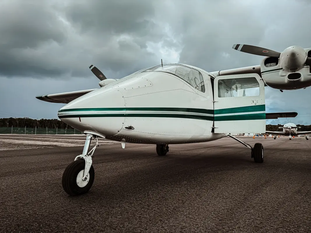 A multi-engine airplane on the tarmac under clouds