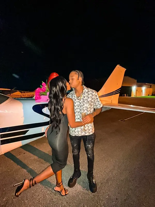 A couple embracing beside a Cessna wing at night