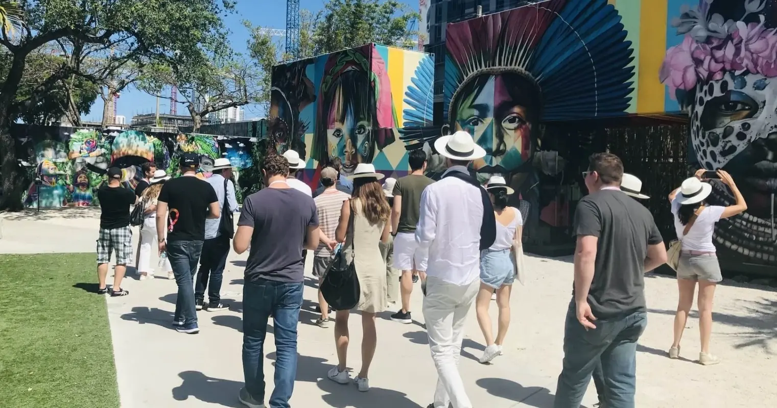 A walking group passing murals inside Wynwood Walls