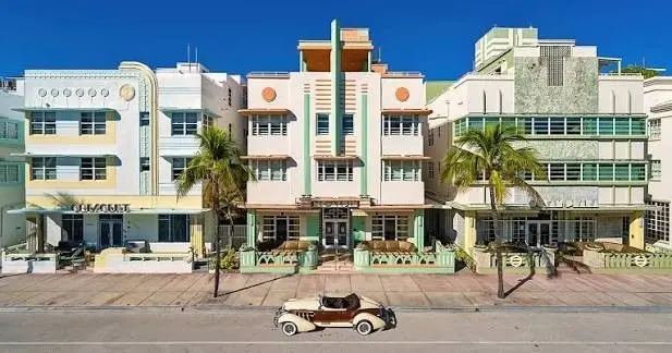 A row of restored Art Deco hotels with a vintage convertible