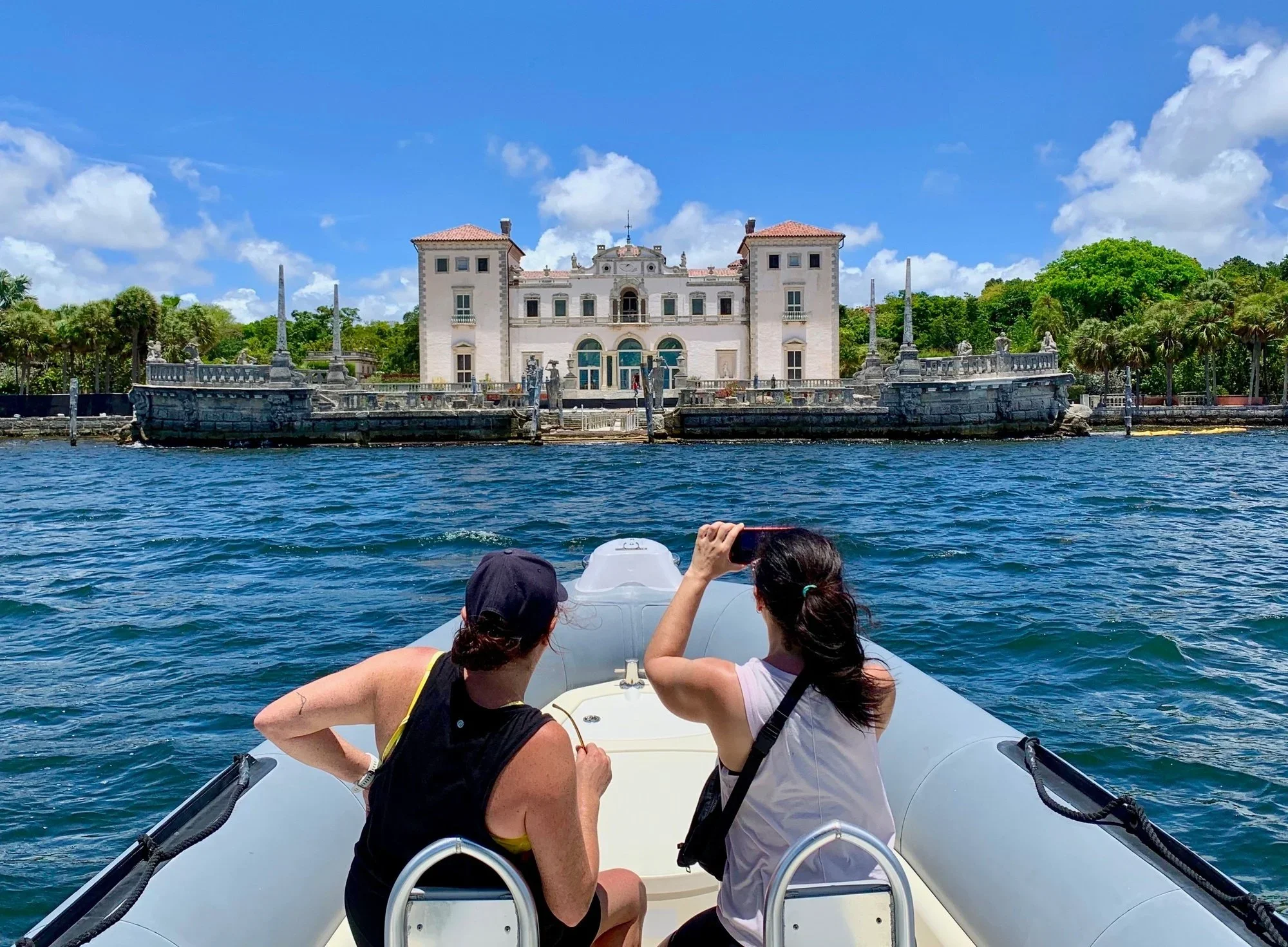 Two passengers photographing Vizcaya museum from the water