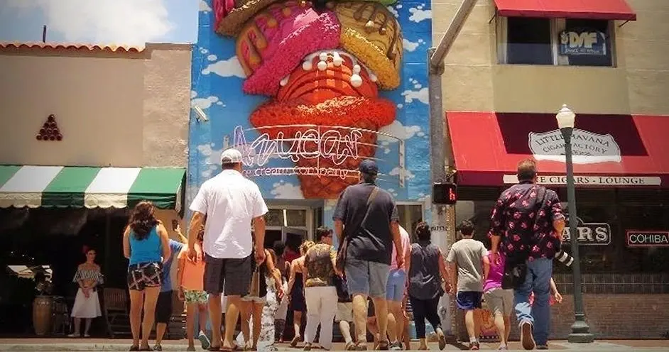 Tour group crossing Calle Ocho toward a Little Havana ice cream shop and cigar factory