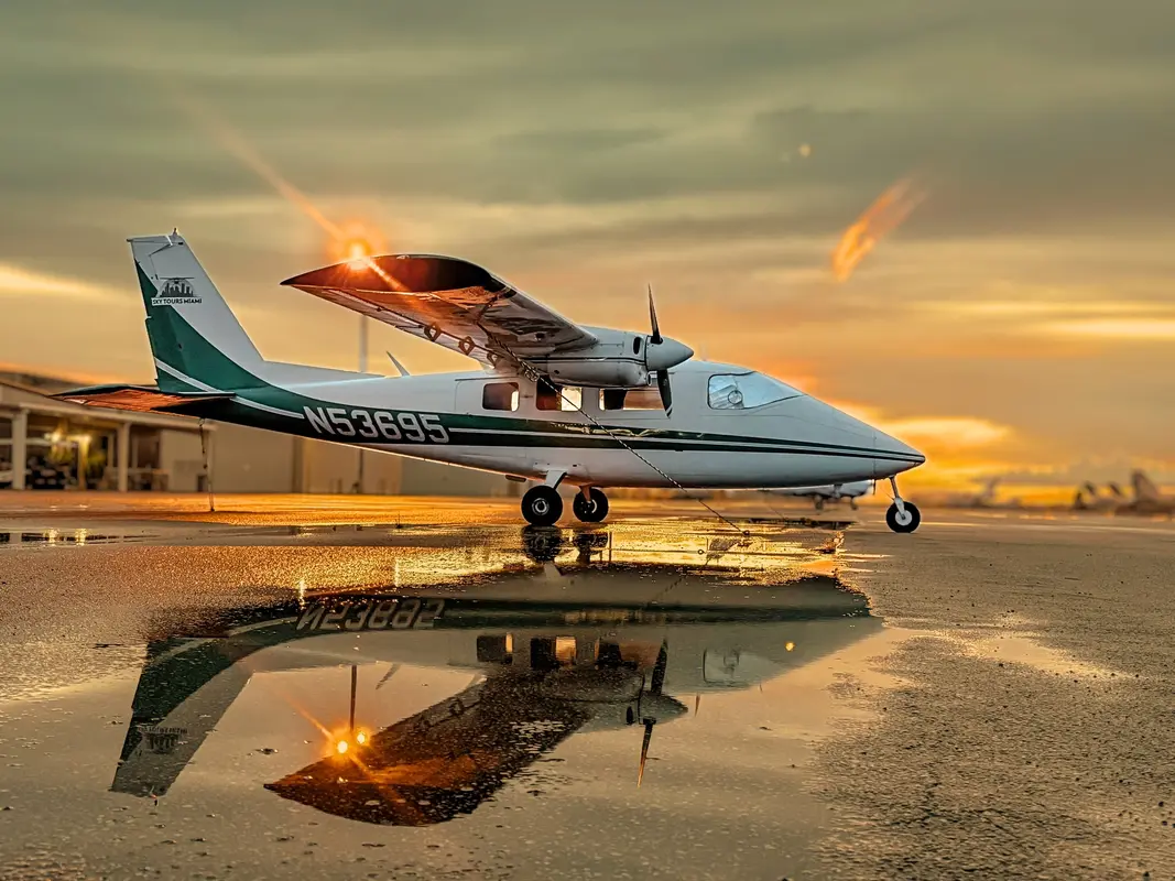 A green-striped multi-engine airplane at sunset