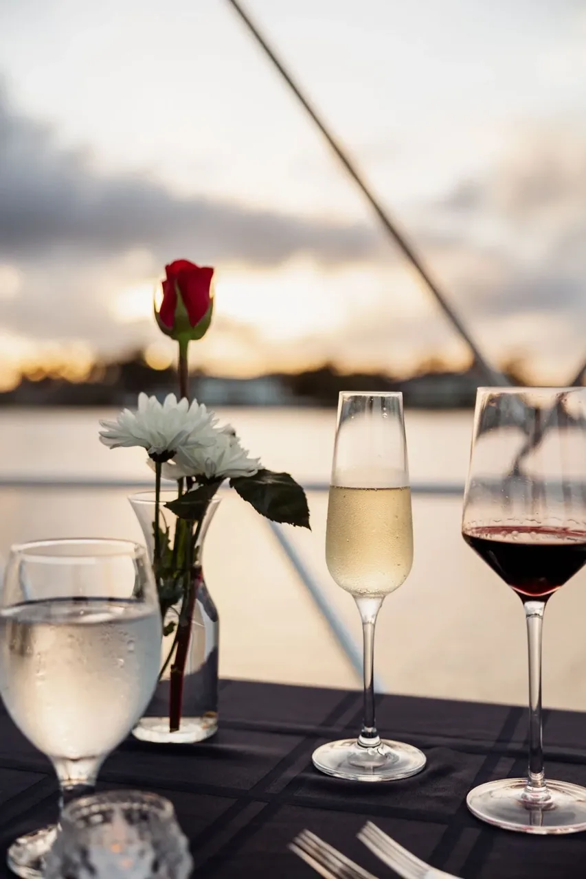 Wine glasses and flowers on a boat table in evening light
