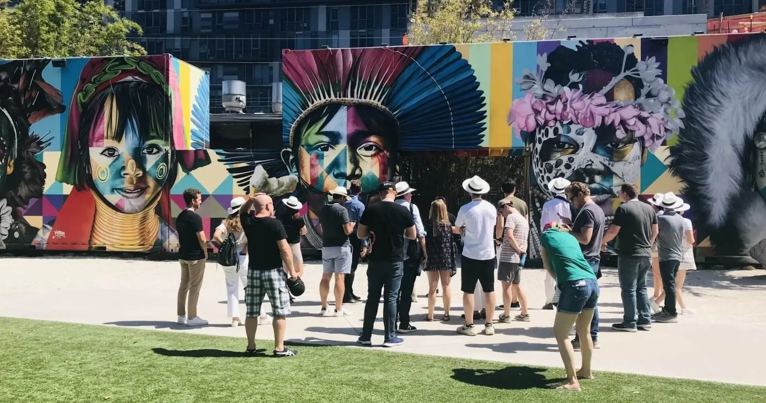 A tour group in front of large portrait murals in Wynwood Walls