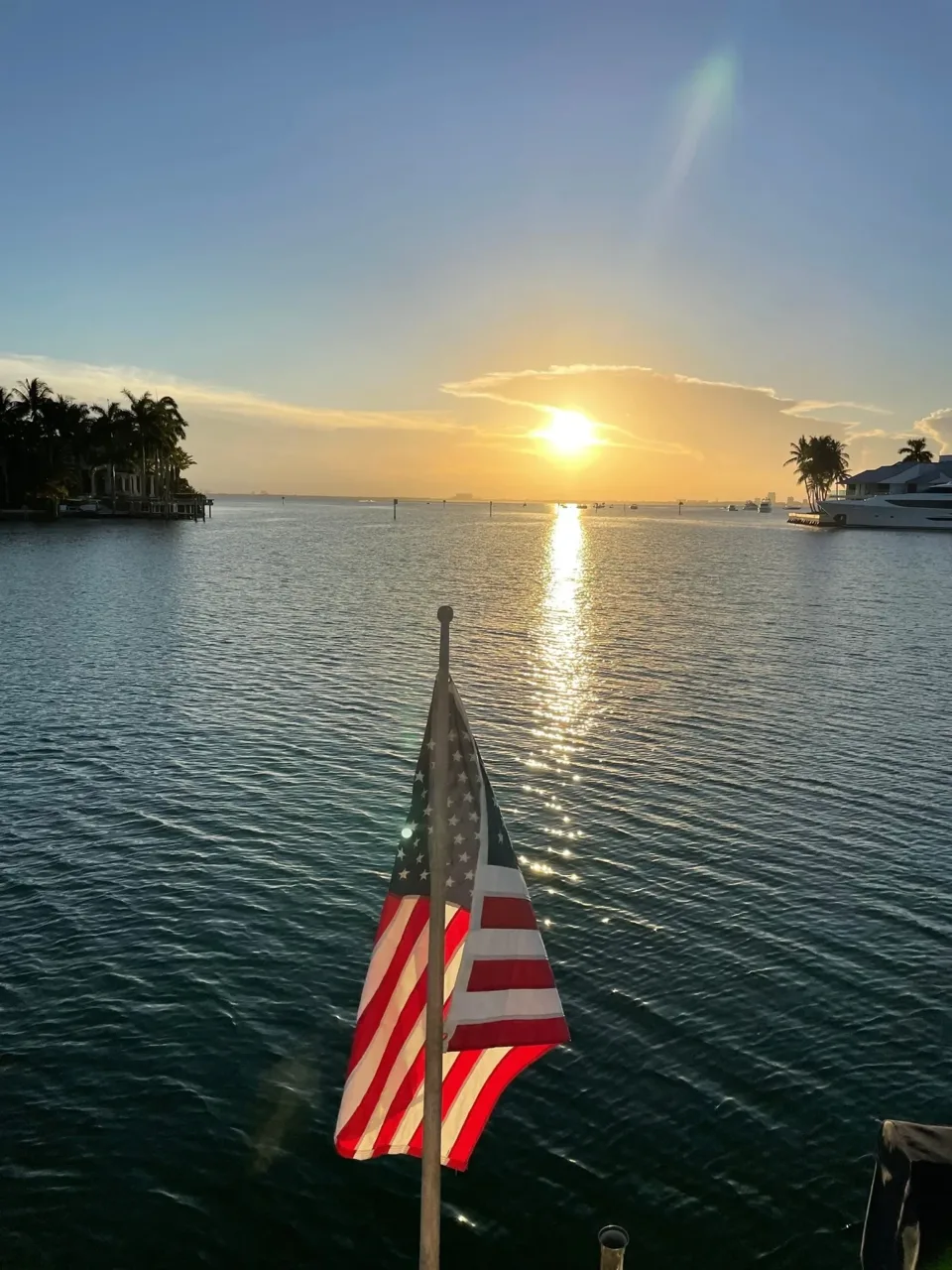 An American flag on a boat facing a golden sunset