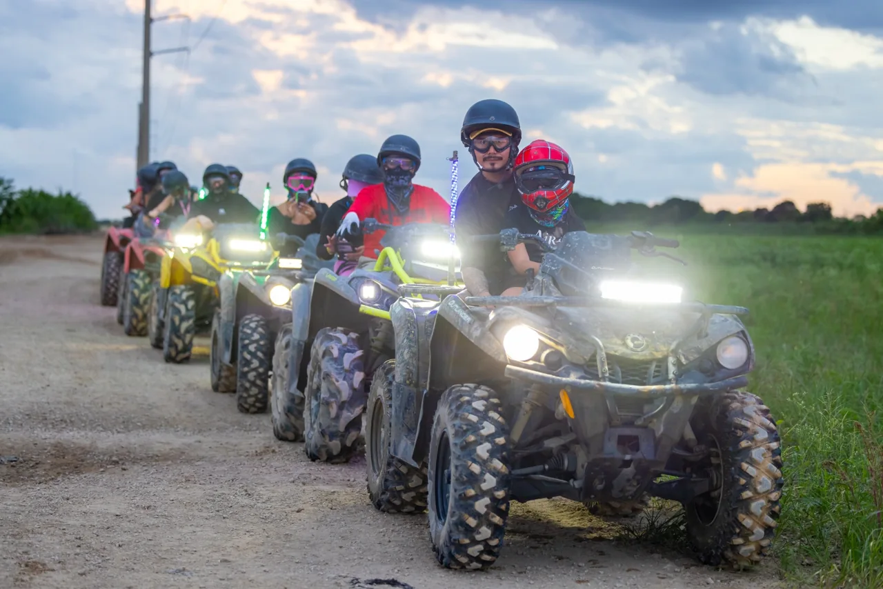 A line of ATV riders on a dirt track
