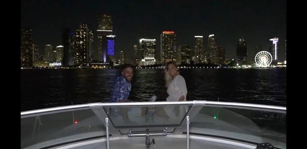 Passengers on a boat overlooking the Miami skyline at night