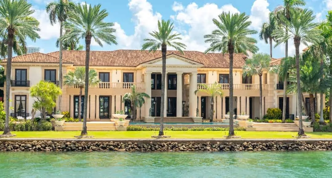 A waterfront house framed by palm trees