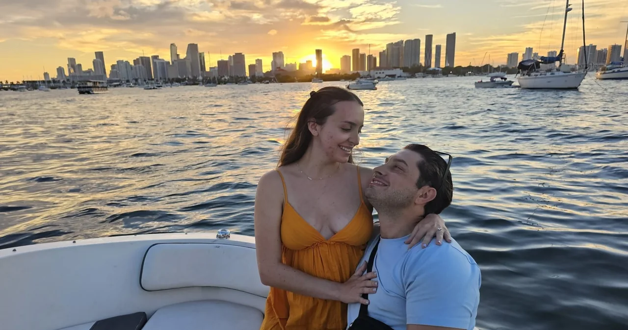 A couple seated in a motorboat in evening light