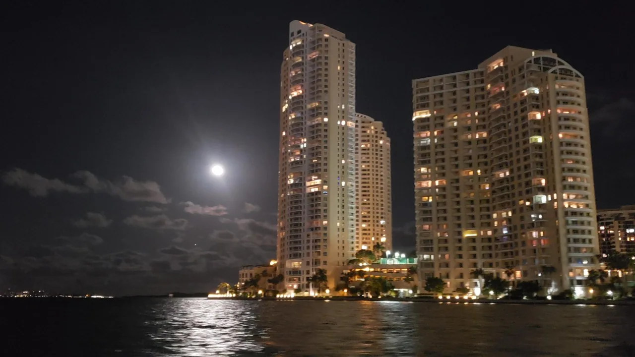 An illuminated waterfront observation wheel beside Miami high-rises