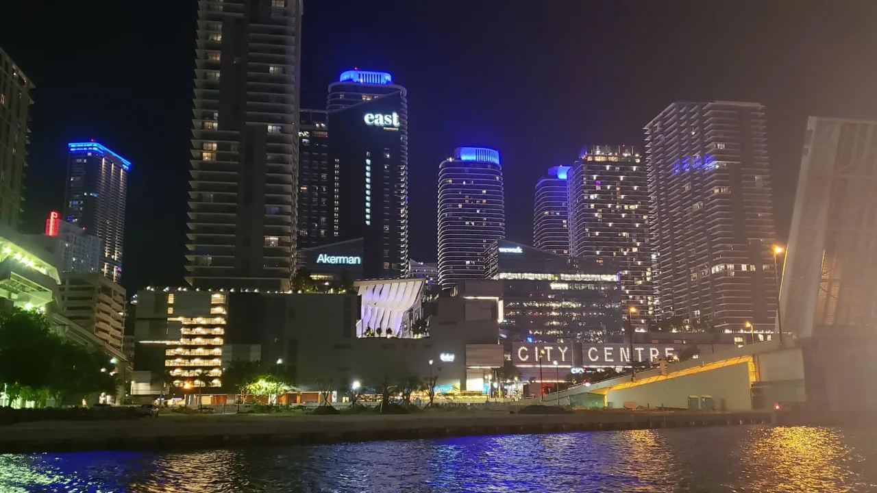 Miami waterfront towers illuminated in blue and purple at night