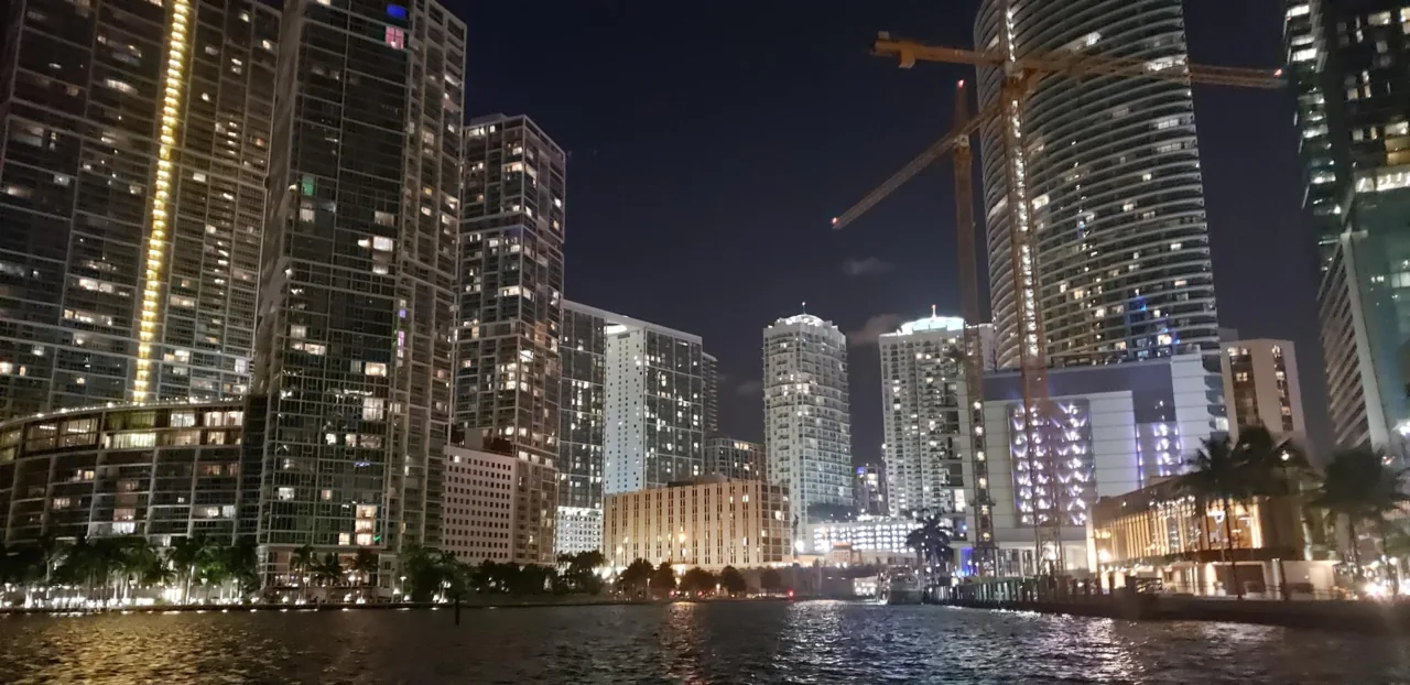 Illuminated waterfront buildings reflected on the bay