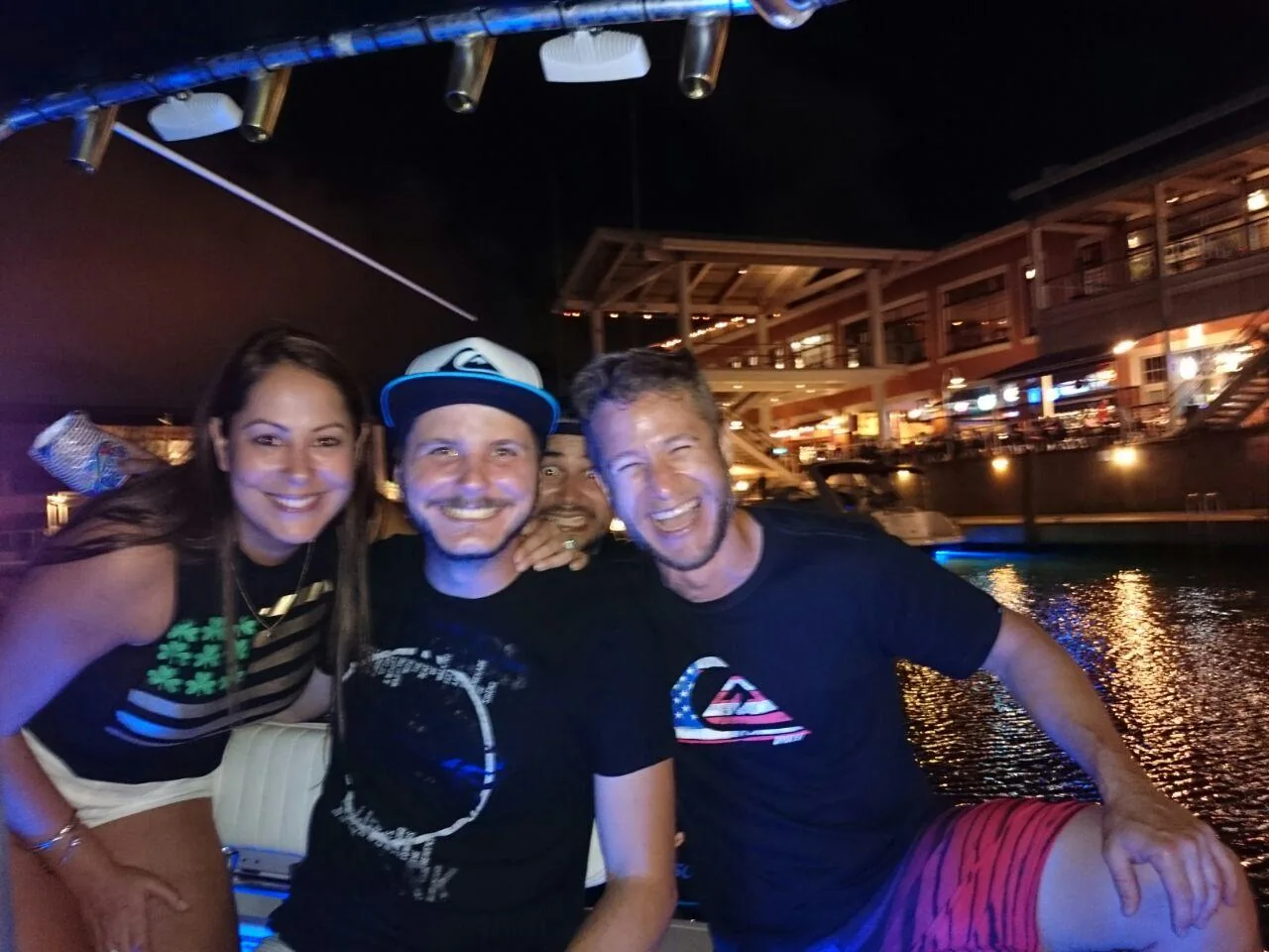 Passengers smiling aboard a boat at night