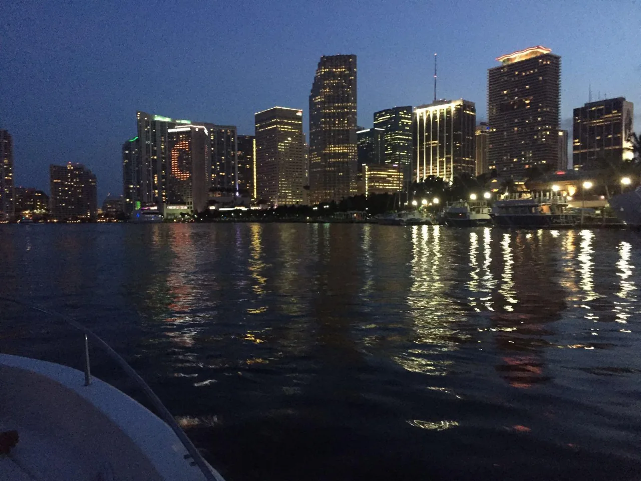 Waterfront towers reflected in dark bay water