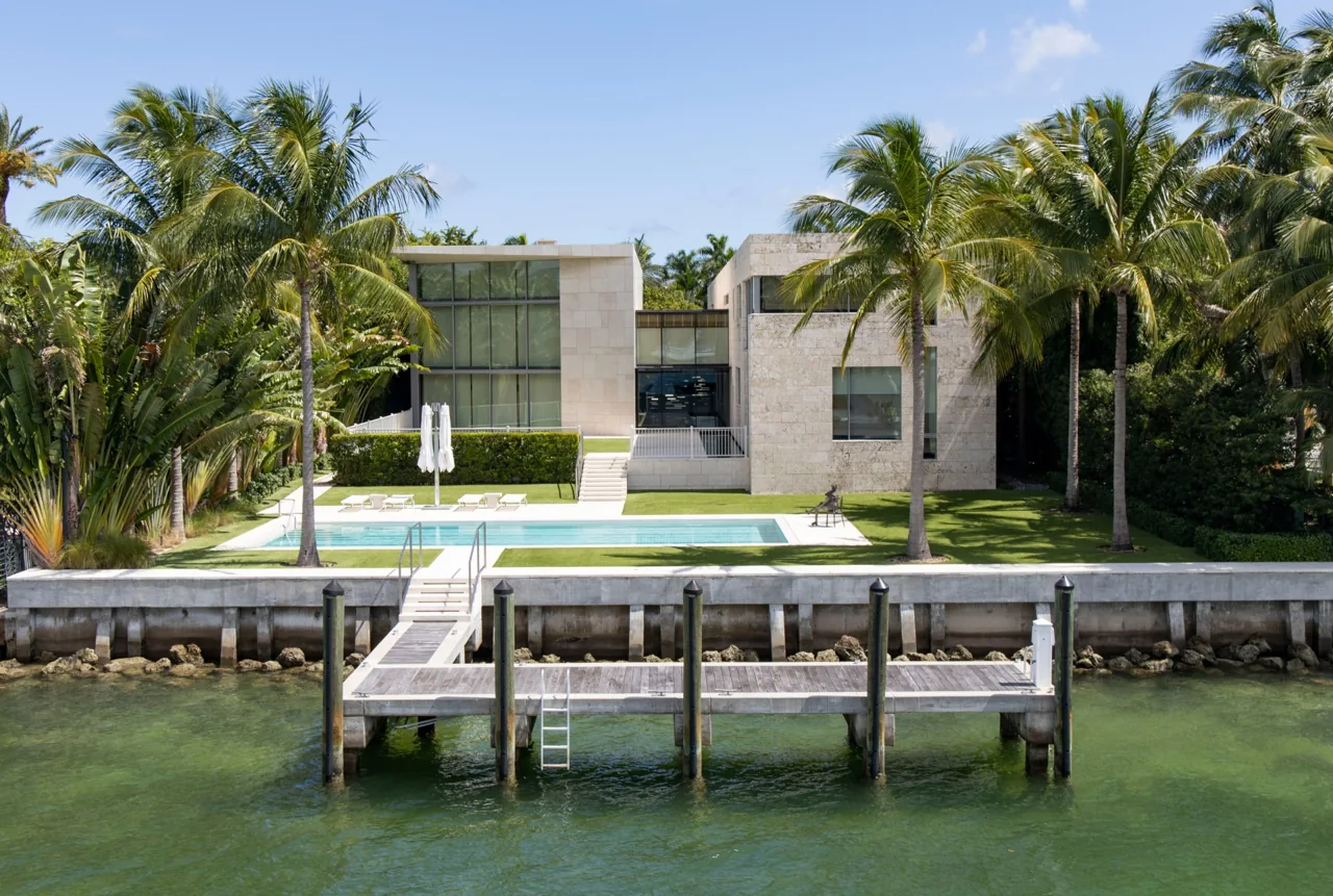 A waterfront home with palm trees and a private dock