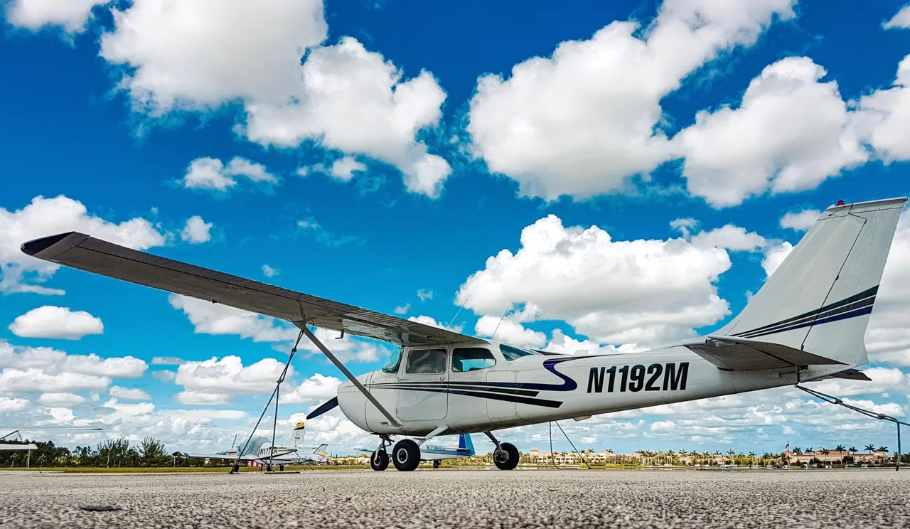 A white propeller airplane on the airport apron