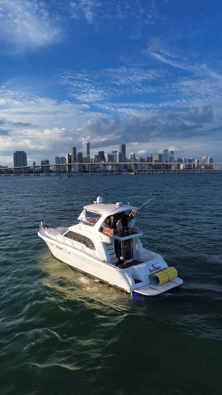 Passengers on the aft deck of a yacht with the Miami skyline beyond