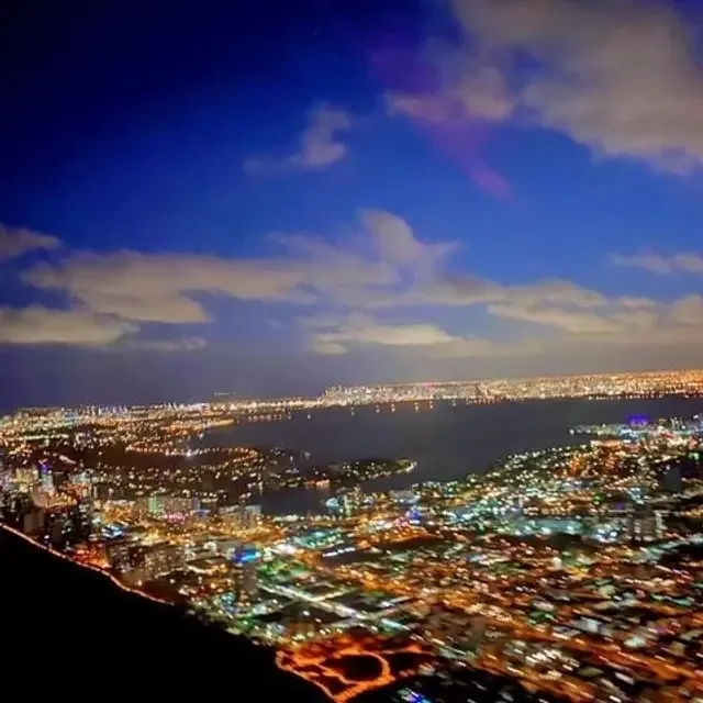 Aerial view of illuminated city streets beneath an evening sky