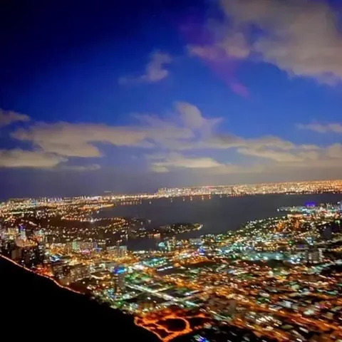 Aerial view of illuminated city streets beneath an evening sky