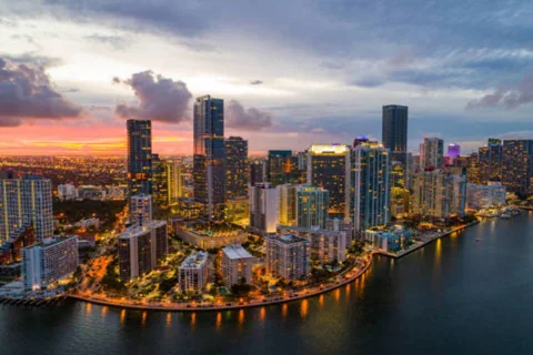 Miami waterfront buildings beneath a warm sunset sky