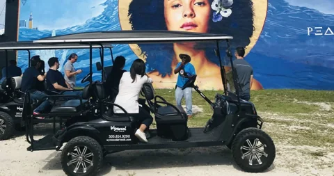 A golf cart parked in front of a Wynwood mural